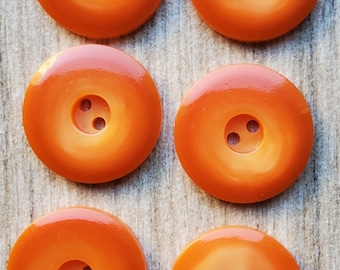 Vintage set of six orange plastic buttons.