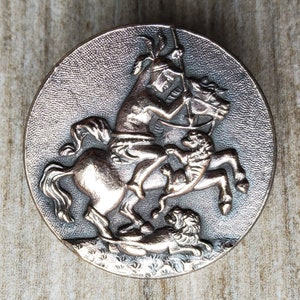 Vintage coppered silver button of horse back rider slaying lion.
