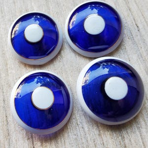 Set vintage di quattro grandi bottoni in vetro blu trasparente e smalto degli anni 1900.