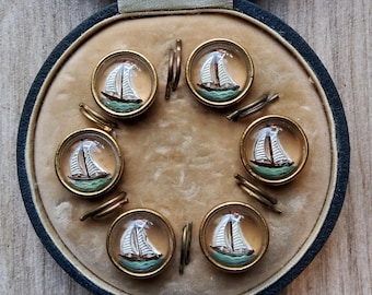Vintage boxed set of six 1900's glass sailing boat waistcoat buttons.