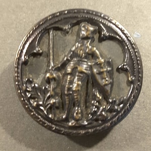 Vintage button of Knight in armour with jousting lance.