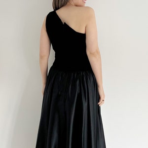 Vintage black full circle one shouldered prom dress. The bodice of the dress is velvet with a full skirt section of the dress.  The dress is mid calf and ideal for parties, occasions or the prom.  UK 12 14 today