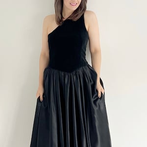 A handmade vintage black occasion 80s dress.  The dress features one shoulder and a slight V waist.  The dress has a full circle black skirt section.  A great vintage party dress. UK 12 14 today