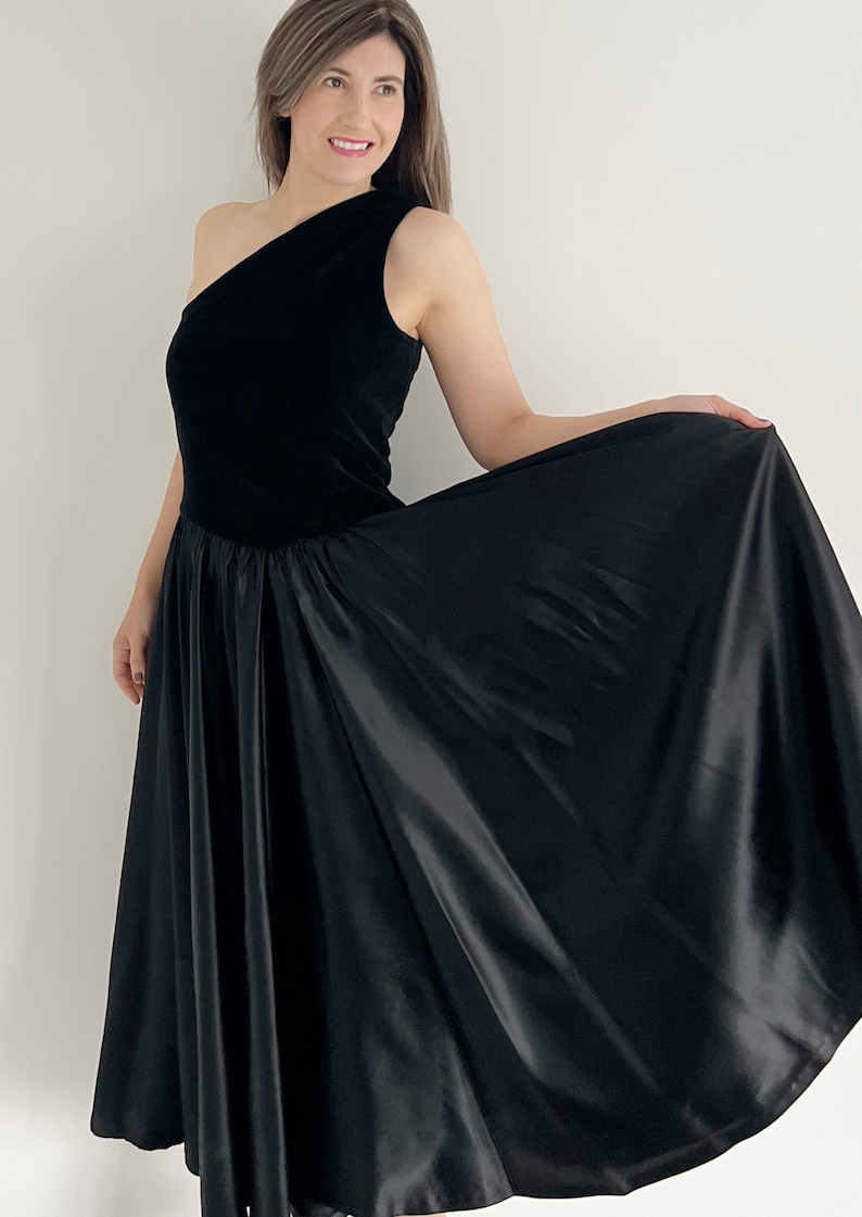 A beautiful vintage black handmade prom dress with one shoulder.  The dress has a full circle skirt section, a velvet bodice. The dress is a UK 12