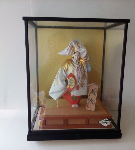 geisha doll in glass case