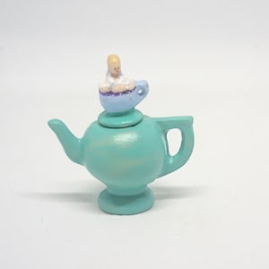 teapot with a baby on the lid