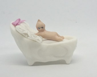 porcelain Kewpie doll in a cradle