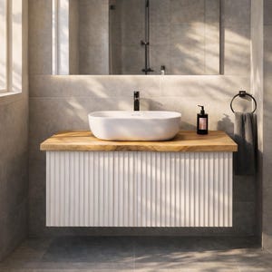 Peut inclure: Un meuble-vasque de salle de bain moderne avec un meuble blanc nervuré et un plan de travail en bois clair. Un lavabo ovale blanc est posé sur le comptoir, avec un robinet noir. Un grand miroir est suspendu au-dessus de la vanité.