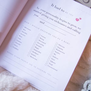 May include: A white page from a baby memory book with a checklist of personality traits. The checklist is titled "How I Would Describe You As A Baby." The traits include "Affectionate", "Alert", "Articulate", "Assertive", "Bossy", "Calm", "Cautious", "Cheerful", "Clever", "Confident", "Curious", "Daring", "Determined", "Easy-going", "Energetic", "Happy", "Independent", "Intelligent", "Intuitive", "Mischevious", "Observant", "Outgoing", "Rambunctious", "Sensitive", "Shy", "Stubborn", "Sweet", "Talkative", "Tough", and "Unconventional".