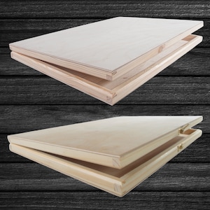 Könnte beinhalten: Zwei Holzkisten mit Scharnierdeckeln, beide geöffnet, um das Innere zu zeigen. Die Kisten sind aus hellem Holz und haben eine natürliche Oberfläche.