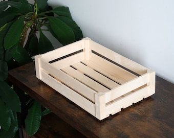Peut inclure: Une caisse en bois naturel de forme rectangulaire. La caisse est en bois brut et a un aspect rustique.