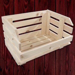 Op de afbeelding: Een houten kist met een natuurlijke afwerking. De kist is leeg en heeft een rechthoekige vorm. De kist is gemaakt van houten latten en heeft een rustieke uitstraling.