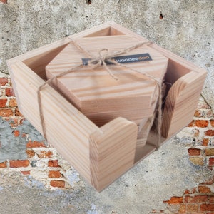 Op de afbeelding: Een set van zes houten zeshoekige onderzetters in een natuurlijke houtkleur, verpakt in een houten doos met het woord "woodeedoo" erop gedrukt.