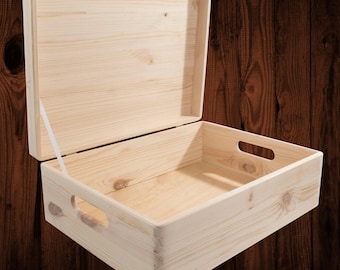 May include: A rectangular light-colored wooden storage box with an open hinged lid. The box features a natural wood grain finish, visible knots, and two oval-shaped cut-out handles on the sides. A thin white ribbon holds the lid open.