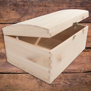May include: A natural wood chest with a hinged lid and brass hardware. The chest is open and the inside is visible. The chest is sitting on a wooden surface.