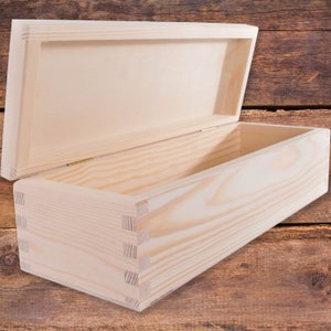 May include: A plain wooden box with a hinged lid. The box is made of light-coloured wood and has a natural finish. The lid is open and the inside of the box is visible.
