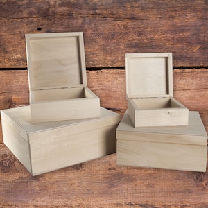 May include: Three wooden boxes with lids, the largest box is on the bottom and the smallest box is on top. The boxes are made of unfinished wood and are ready to be painted or stained.