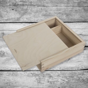 May include: A wooden box with a hinged lid and a small compartment inside. The box is made of light-coloured wood and has a natural finish.