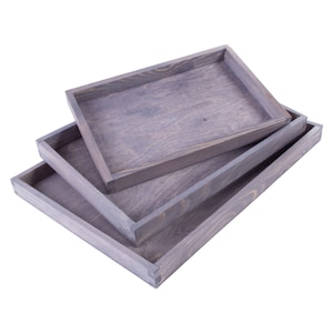 May include: Three wooden trays stacked on top of each other. The trays are all the same size and shape, and they are made of a light brown wood. The trays are all empty.
