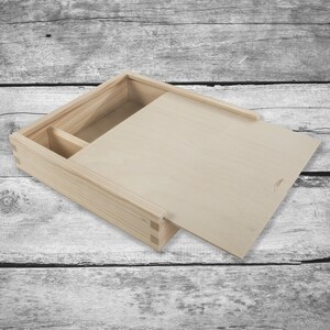 May include: A natural wood box with a hinged lid and a small compartment inside. The box is open and the lid is propped up.