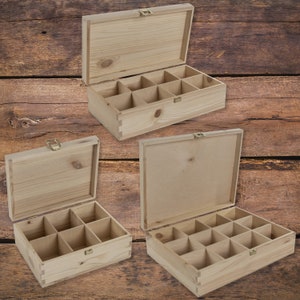 May include: Three wooden boxes with lids open, each box has nine compartments. The boxes are made of light brown wood and have brass hinges and clasps.