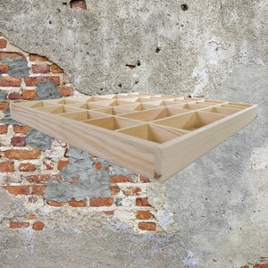 May include: A wooden storage box with multiple compartments. The box is made of light wood and has a rectangular shape.