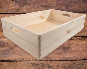 May include: A natural wood storage box with two handles on the sides. The box is empty and sitting on a wooden surface.
