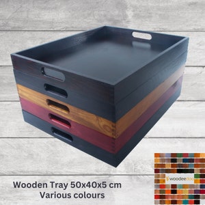 Könnte beinhalten: Stapel aus vier Serviertabletts aus Holz in verschiedenen Farben, darunter Schwarz, Braun, Rot und Naturholz. Jedes Tablett misst 50x40x5 cm und hat zwei Griffe. Die Tabletts werden vor einem grauen Holzmaserungshintergrund gezeigt. Der Text "woodeedee.doc" ist in der unteren rechten Ecke des Bildes sichtbar.