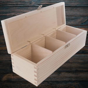 Può includere: Una scatola di legno con un coperchio incernierato e quattro scomparti. La scatola è realizzata in legno chiaro non finito e ha un design semplice.