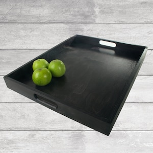 Puede incluir: Una bandeja de servir de madera negra con dos asas. La bandeja está vacía, excepto por tres manzanas verdes.