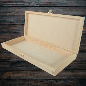 May include: A wooden box with a hinged lid and a brass latch. The box is made of unfinished wood and is ready to be painted or stained.