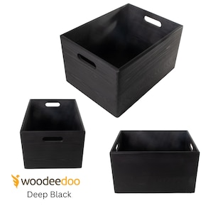 Puede incluir: Tres cajas de almacenamiento de madera negra con asas. Las cajas son de madera y tienen un acabado negro intenso. Las cajas son de diferentes tamaños.