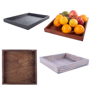 Può includere: Quattro vassoi in legno di diversi colori e dimensioni. I vassoi sono in legno con una venatura naturale. I vassoi sono vuoti, tranne uno che contiene una varietà di frutta.