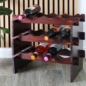 May include: A dark brown wooden wine rack with three shelves, each holding six bottles of wine. The rack is made of solid wood and has a rustic finish. The bottles are a mix of red and white wine.