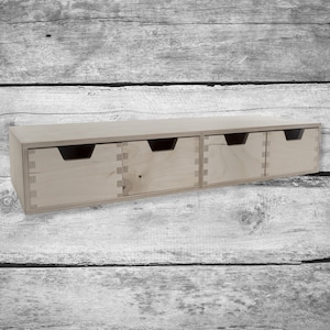 May include: A natural wood drawer unit with four drawers. The drawers are unfinished and have a simple design.