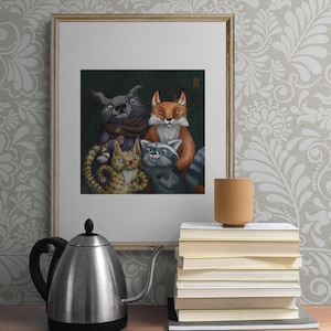 May include: A framed illustration featuring a group of anthropomorphic animals: a wolf, fox, cat, and raccoon. The artwork is set against a dark green background. A stack of books and a brown mug sit on a wooden surface, with a silver kettle in the foreground.