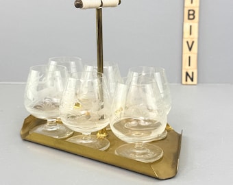 Juego de vasos de chupito de los años 50/60 sobre una bandeja de latón con 6 mini copas de brandy, decorado con motivos de animales del bosque y caza. Decoración de bar de mediados de siglo con temática de caza.