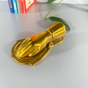 large paper clip, paper clip, clip in the shape of a hand, brass, vintage