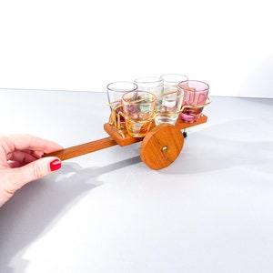 Borrelglaasjes kleurrijke vintage in een standaard hooiwagen, kruiwagen