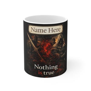Op de afbeelding: Witte keramische mok met een zwarte achtergrond met een middeleeuws krijgerontwerp. De mok heeft de tekst "Name Here" bovenaan en "Nothing is true" onderaan, met een zwaard- en kasteelillustratie.