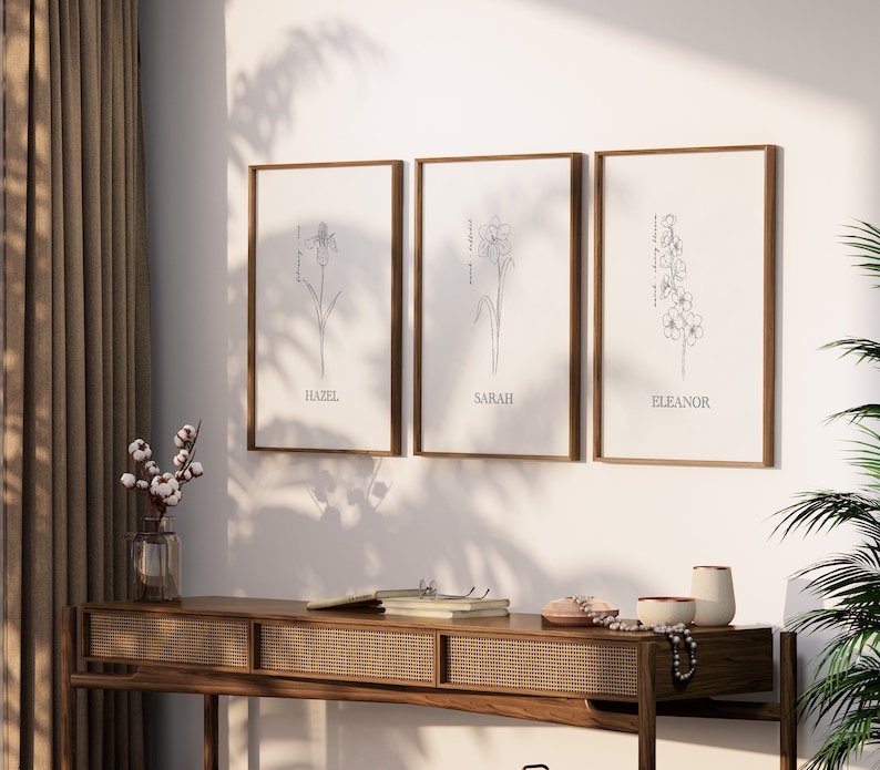 Includes: Three framed prints with black and white line drawings of your choice of birth month flowers. Each print has a name at the bottom: Hazel, Sarah and Eleanor are examples.