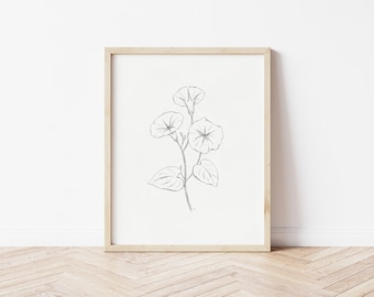 May include: A black and white line drawing of a flower with five petals, a stem, and leaves. The drawing is framed in a light wood frame and is hanging on a white wall.