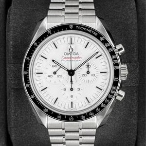 May include: A stainless steel Omega Speedmaster Professional chronograph watch with a white dial, black tachymeter bezel, and three sub-dials. The watch features black hands, hour markers, and a metal link bracelet with a folding clasp.