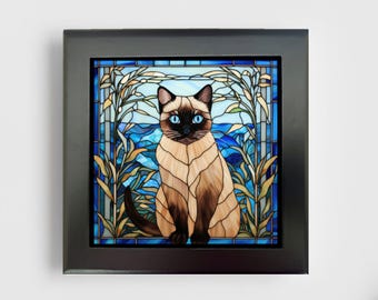 May include: A square framed wall art piece featuring a stained glass style illustration of a Siamese cat with blue eyes. The cat is centered against a background of blue water and tan reeds, all enclosed within a solid black rectangular frame.