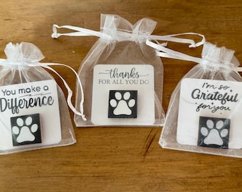 May include: Three white sheer organza drawstring bags, each containing a square black tile with a white paw print. The bags feature white cards with the text: You make a Difference, thanks FOR ALL YOU DO, and I'm so, Grateful for you.