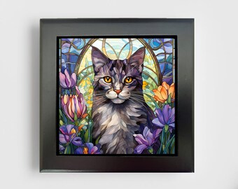 May include: A square framed wall art piece featuring a stained glass style illustration of a gray tabby cat with bright amber eyes. The cat is surrounded by purple and orange flowers and a geometric arched background in shades of blue and yellow.