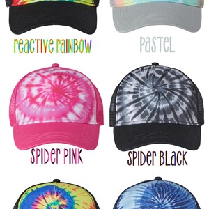 May include: Six different tie-dye trucker hats with a variety of colors and patterns. The hats are all black mesh with a solid colored front panel. The front panels feature a tie-dye pattern in the following colors: reactive rainbow, pastel, spider pink, spider black, neon rainbow, and blue ocean.