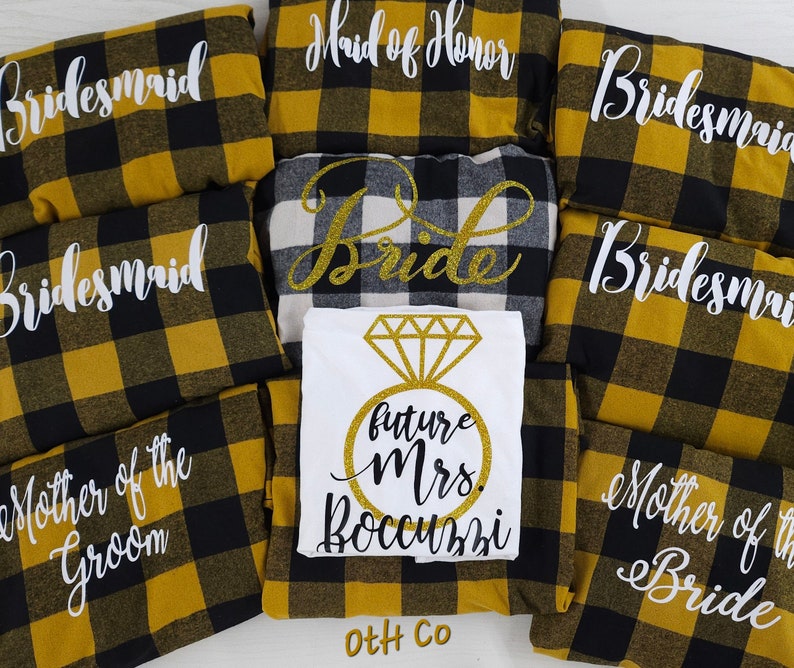 May include: A set of robes in a black and yellow plaid pattern with white text. The robes say "Bride", "Maid of Honor", "Bridesmaid", "Mother of the Groom", and "Mother of the Bride".