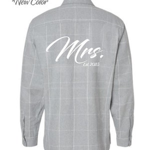 May include: A gray plaid long-sleeve button-down shirt with the word "Mrs." and "Est. 2023" printed on the back in white.