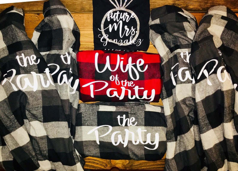 May include: Five black and white plaid flannel shirts with white text. One shirt says "the party", one says "the party", one says "wife of the party", and two say "the party".